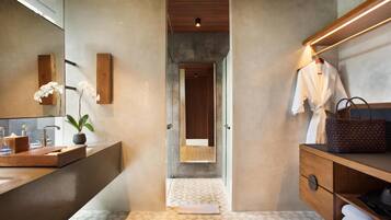 A modern bathroom with a large mirror, wooden vanity, and a towel rack.