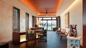 A spacious lobby with a reception desk, seating area, and large windows offering a view of the city.