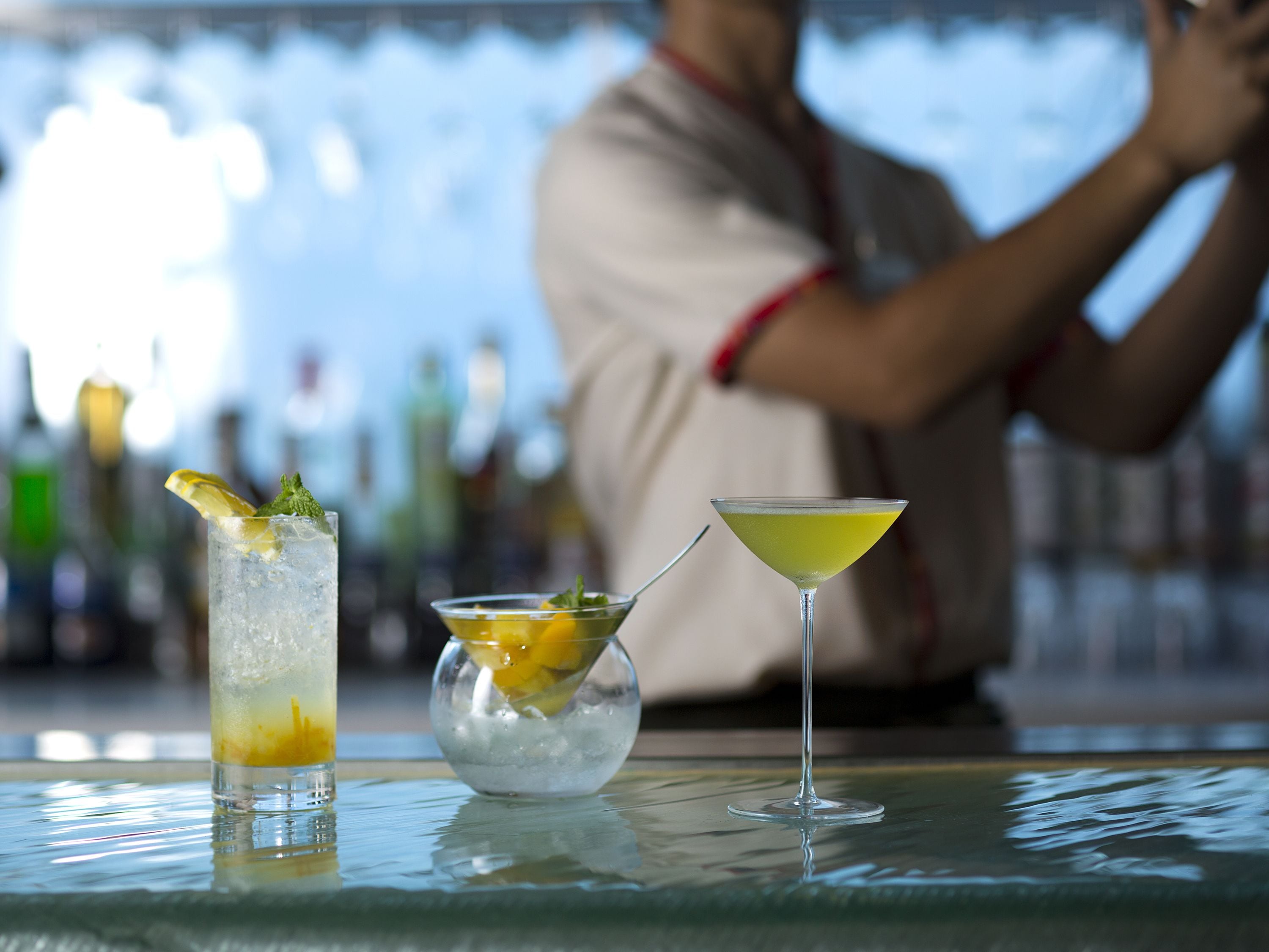 A bar with three drinks on the counter.