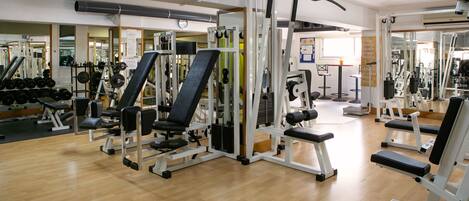 A gym with various exercise equipment, including weight machines and free weights.