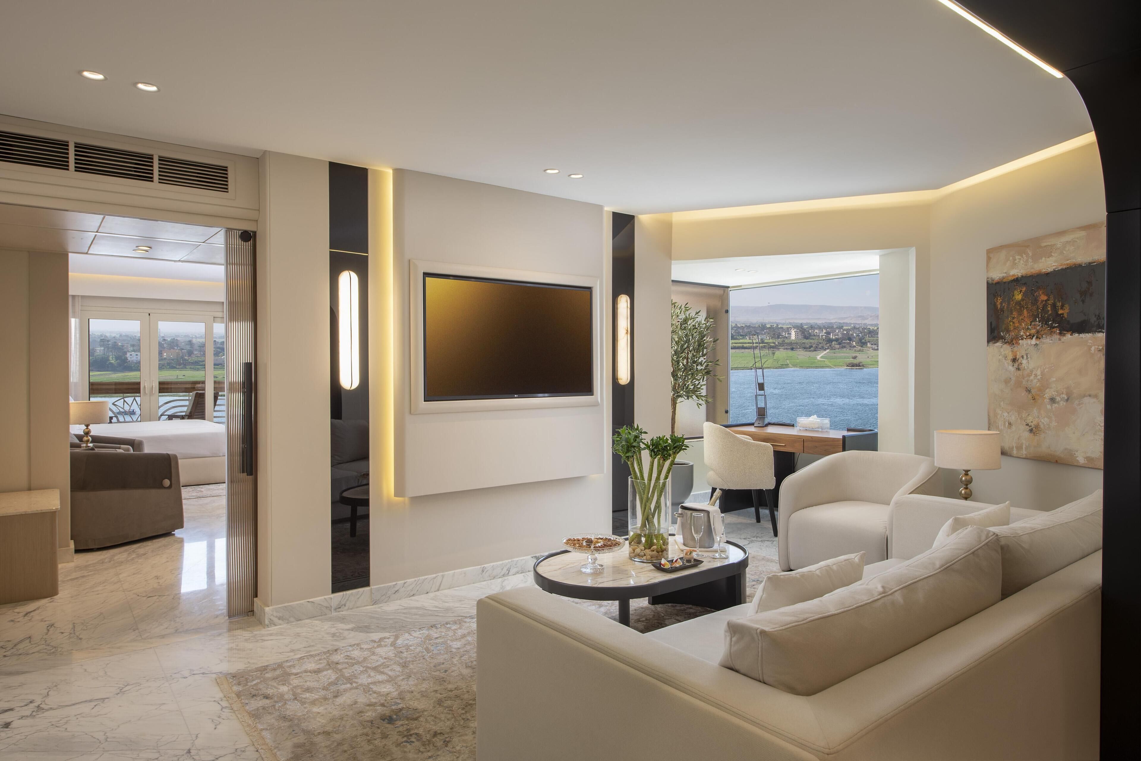 Una sala de estar moderna con un sofá, una mesa de centro y un televisor montado en la pared.
