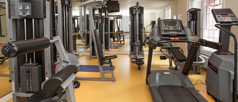 A gym with various exercise equipment, including a treadmill and weight machines.