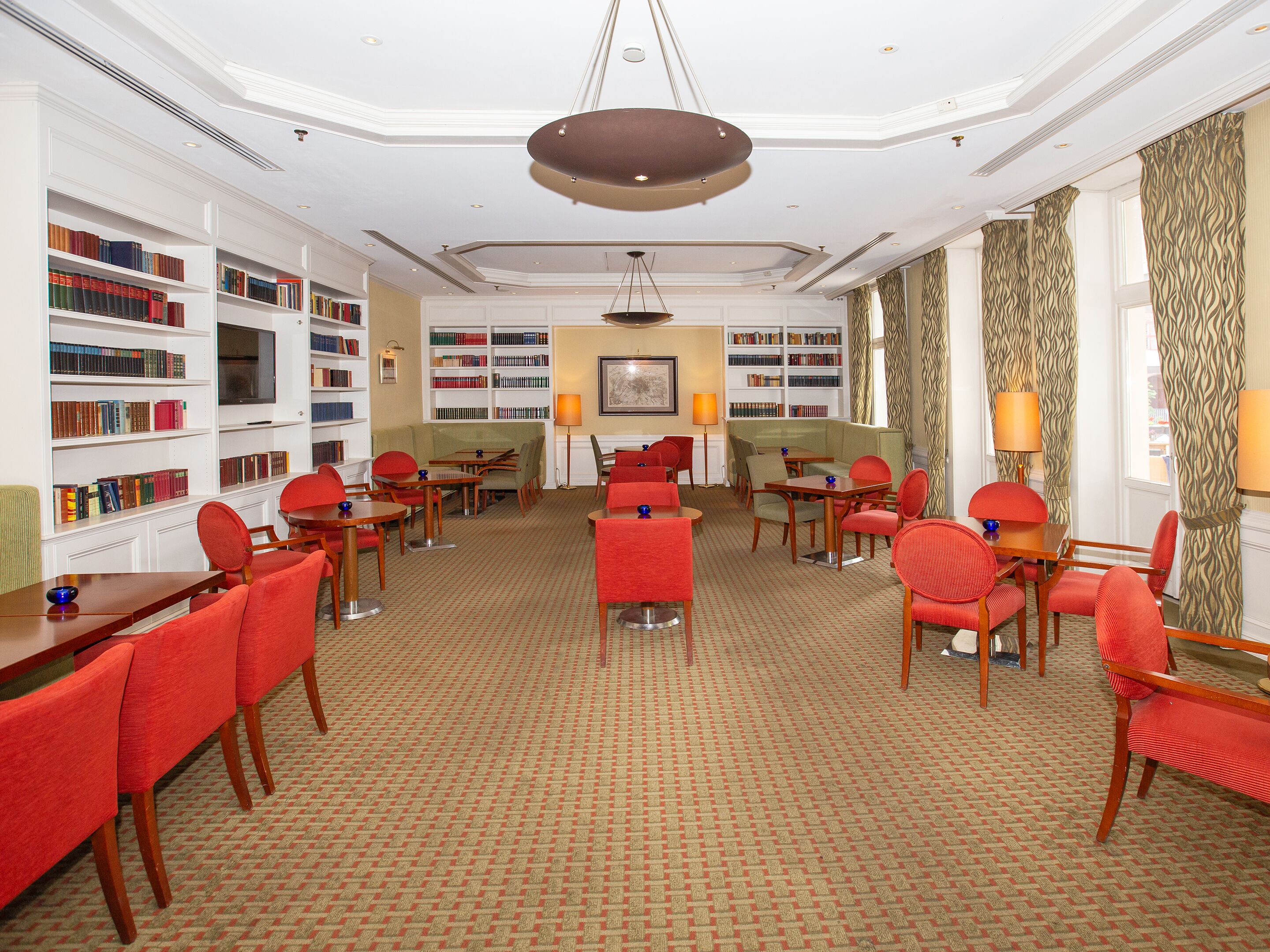 A library with bookshelves, reading tables, and chairs.