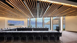 A conference room with a long table, chairs, and a view of mountains and water. - Rendezvous Heritage Hotel Queenstown (Queenstown)