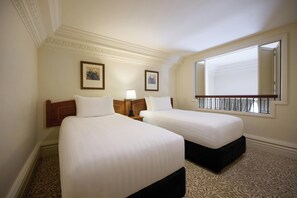 A hotel room with two beds, a window with a view, a framed picture on the wall, and a patterned carpet. - Adina Heritage Christchurch (Christchurch)