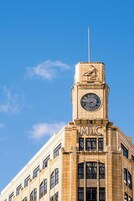 A building with a clock tower and the letters "MIC" on the facade.