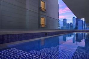 Una piscina al aire libre, sillones reclinables de piscina