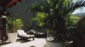 Una piscina al aire libre, sillones reclinables de piscina
