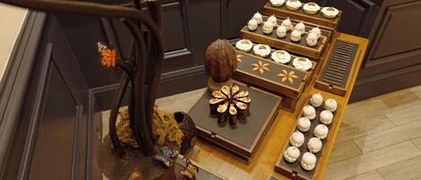 Una selección de pasteles sobre una mesa de madera con detalles decorativos como un árbol y una mariposa.