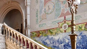 An ornate staircase with intricate carvings and a mural on the wall. - Bussaco Palace Hotel (Mealhada)