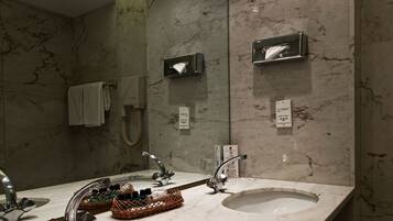 A modern bathroom with two sinks, a large mirror, and a towel rack.