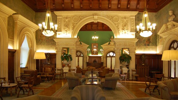A spacious lobby with ornate chandeliers, comfortable seating, and a central fireplace. - Bussaco Palace Hotel (Mealhada)