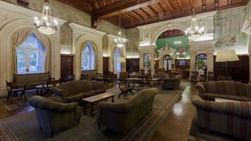 A spacious lobby with high ceilings, ornate chandeliers, and classical architecture.