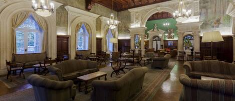 A spacious lobby with high ceilings, ornate chandeliers, and classical architecture.