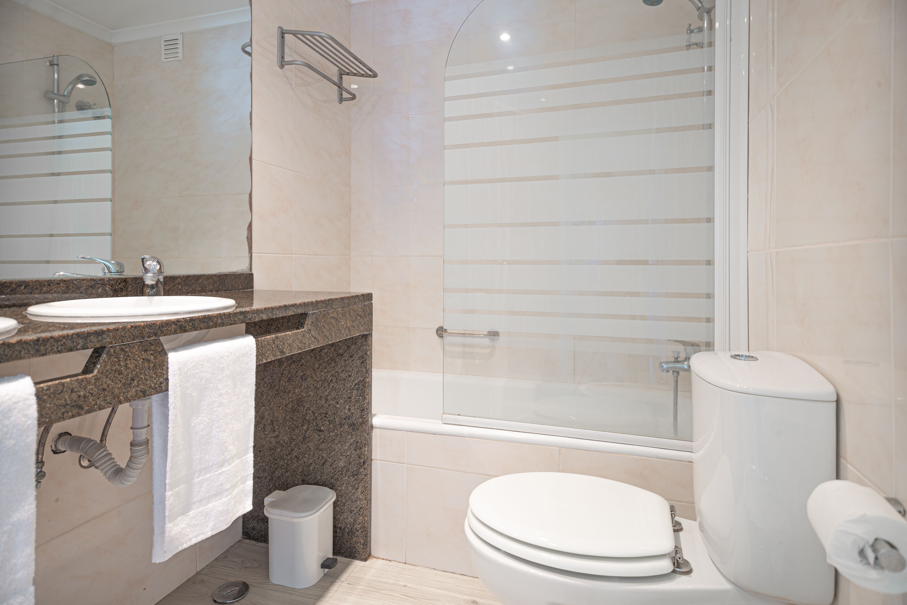 A modern bathroom with a sink, toilet, and glass-enclosed shower.