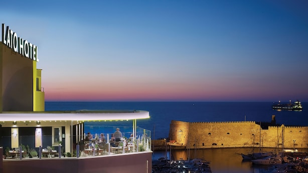 Ein Restaurant am Wasser mit Blick auf das Meer und eine historische Festung.