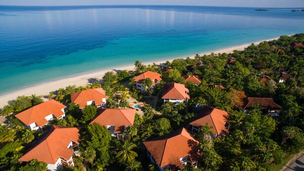 A coastal resort with multiple buildings, a beach, and a clear view of the ocean.