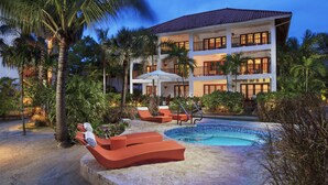 A resort with a pool, lounge chairs, and a multi-story building with balconies.