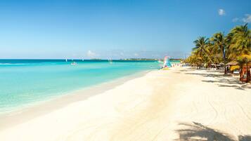 On the beach, white sand, sun loungers, beach towels