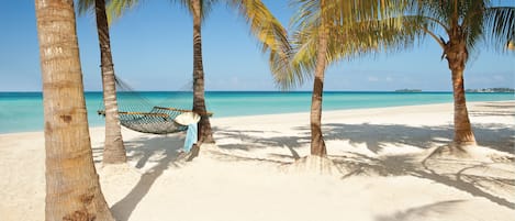 Di pantai, pasir putih, kerusi lepak pantai, tuala pantai