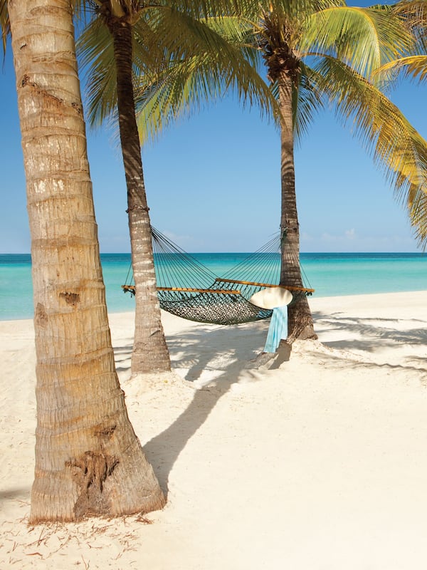 On the beach, white sand, sun loungers, beach towels