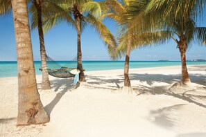 On the beach, white sand, sun loungers, beach towels