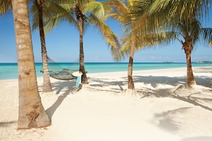 On the beach, white sand, sun loungers, beach towels
