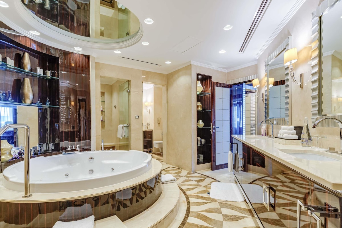 A luxurious bathroom with a large freestanding bathtub, a double vanity with a mirror, and a walk-in shower.