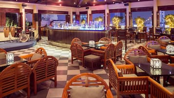 A restaurant with a bar, wooden furniture, and large windows.