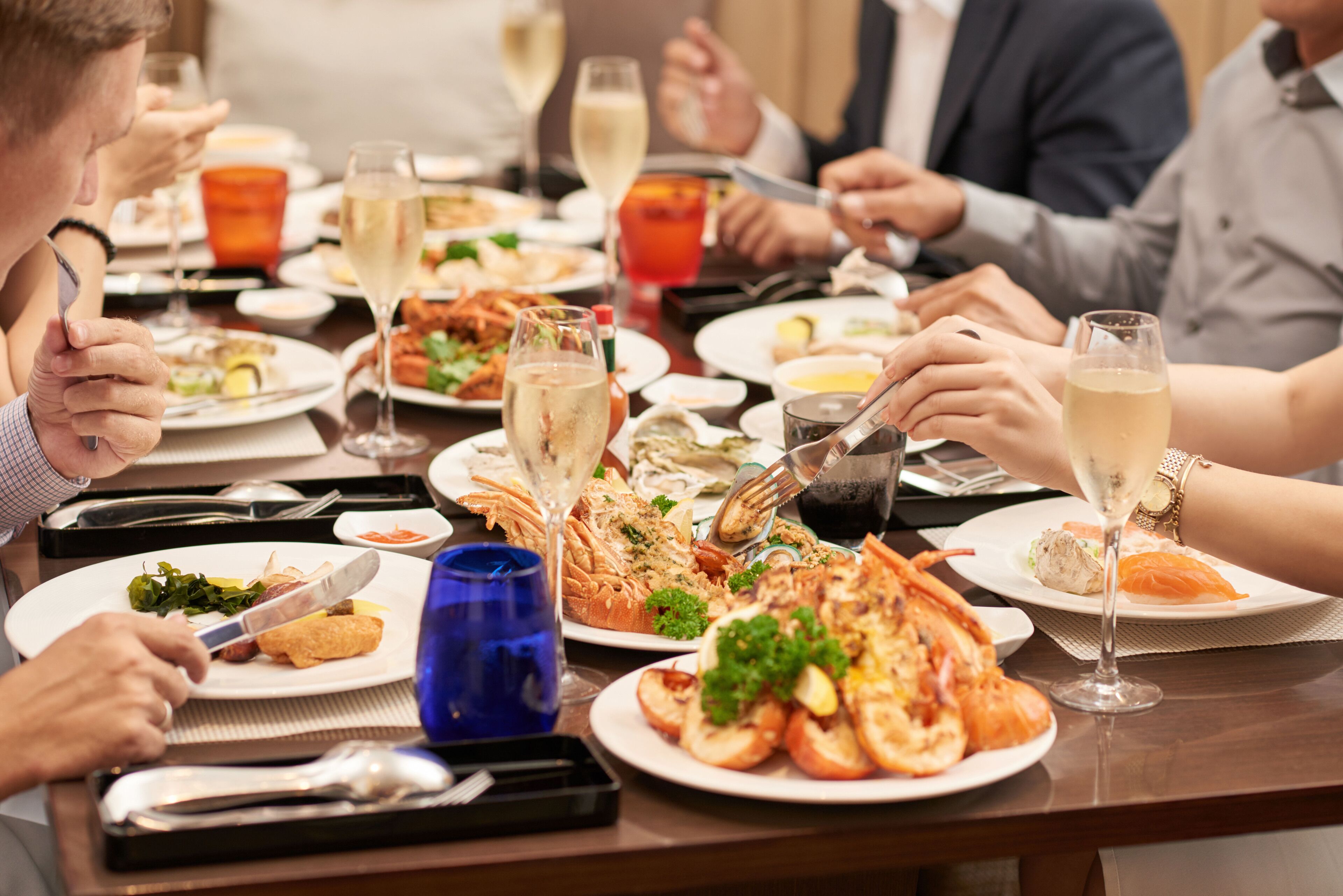 A dining table with various dishes, glasses of wine, and utensils.