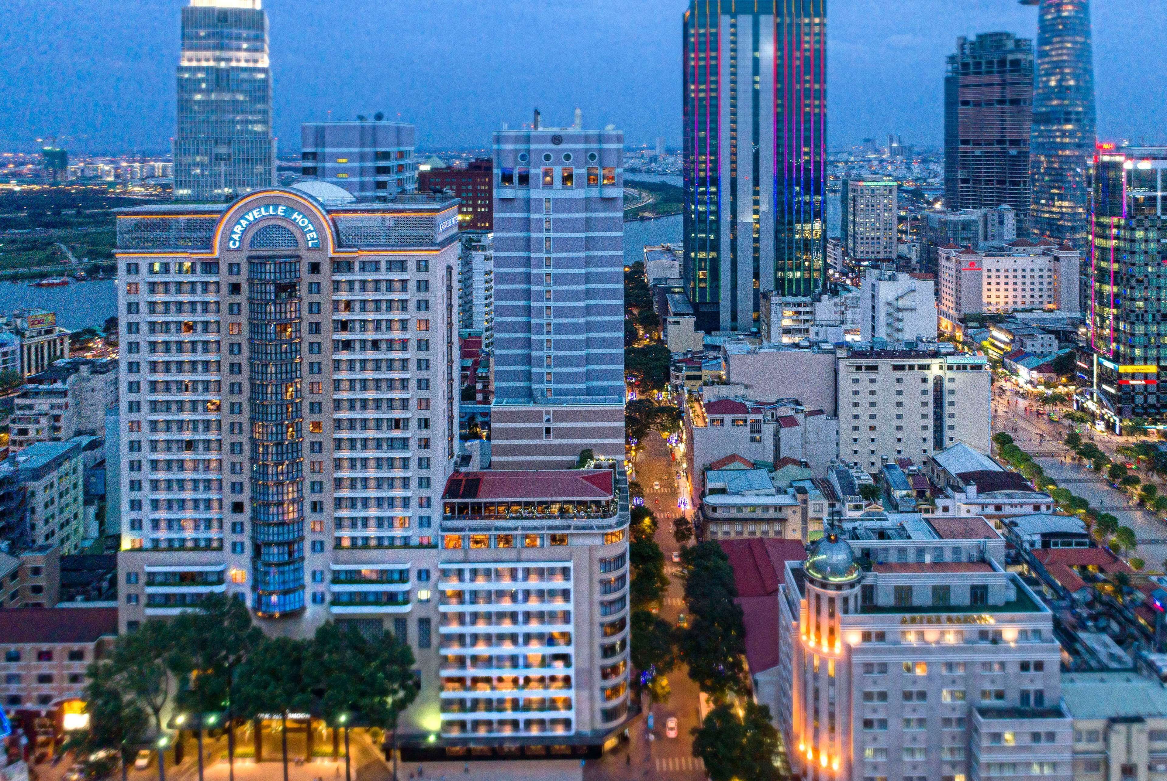 A high-rise hotel with multiple floors, a prominent sign, and a view of the cityscape.