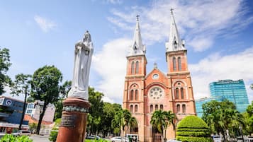 A church with two spires and a statue in front.