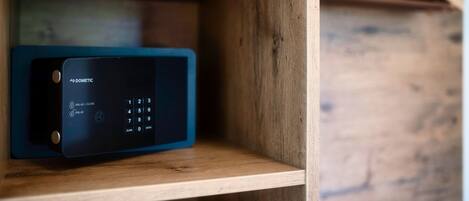 Un dispositivo electrónico negro con teclado y opciones de PIN sobre una estantería de madera.