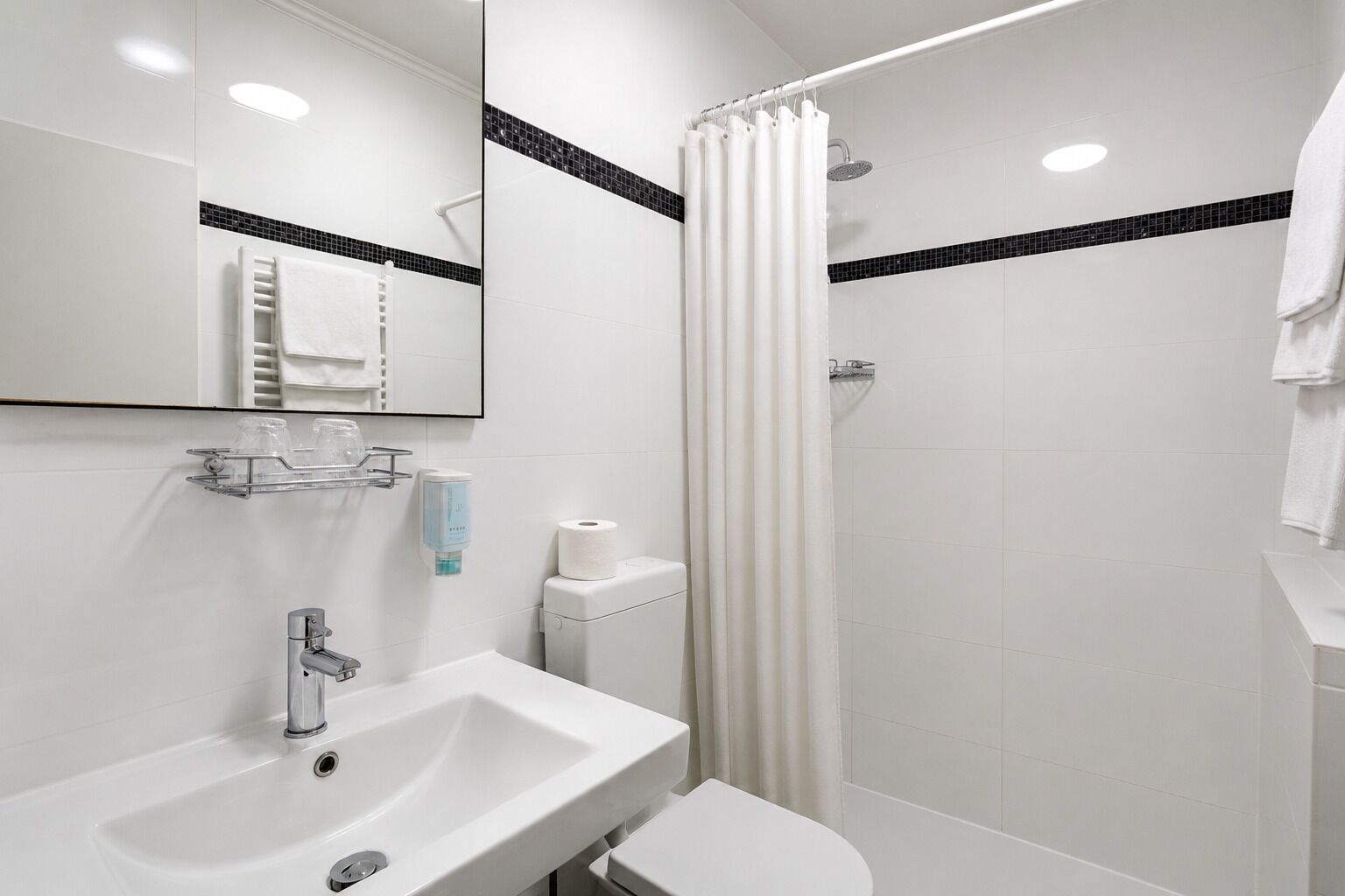 Un bagno moderno dotato di lavabo, WC e doccia.