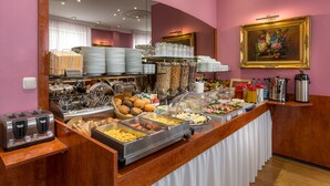 Un bufé con diferentes opciones de comida, utensilios y una estación de café.