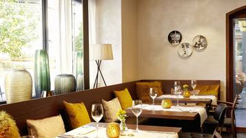 Un restaurante con una decoración moderna, con mesas y cabinas de madera, y vistas a la calle.
