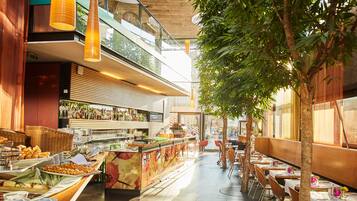 Un restaurante con zona de bar, bufé y asientos.