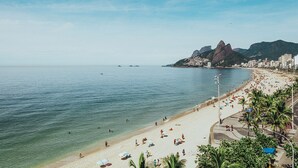 Una playa con aguas cristalinas, una orilla arenosa y montañas al fondo.