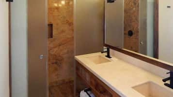 Un baño con dos lavamanos, un espejo y una ducha.