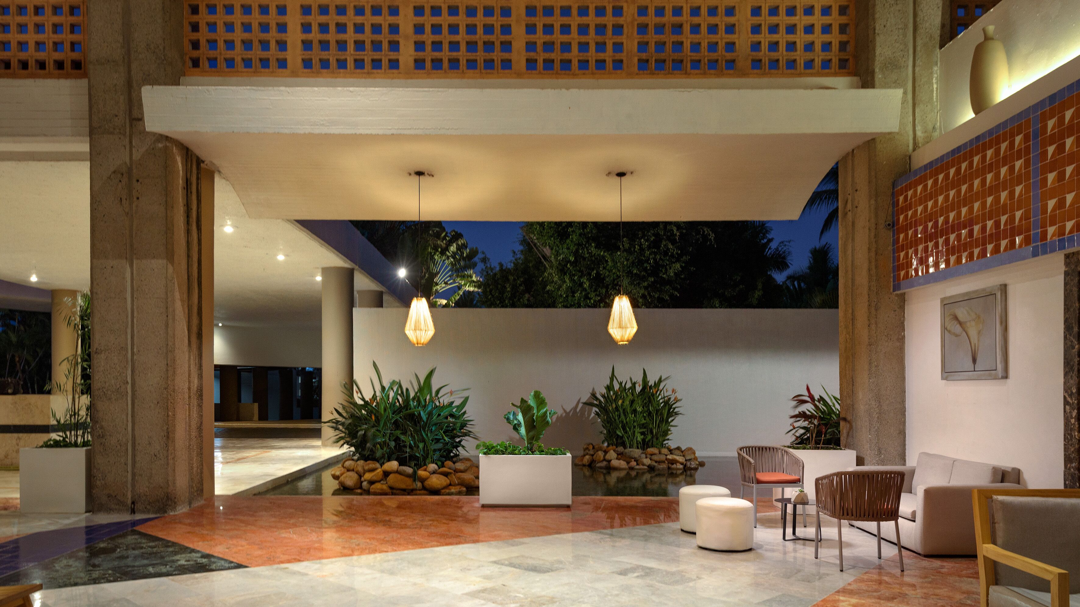 A spacious lobby with a high ceiling, large windows, and a seating area with modern furniture.