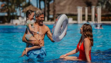 Alberca al aire libre, sombrillas en la alberca y camastros