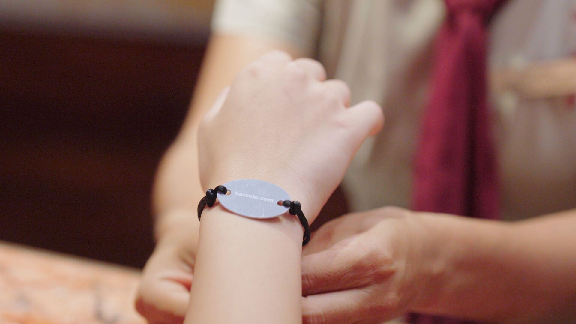 A bracelet with a tag on a wrist.
