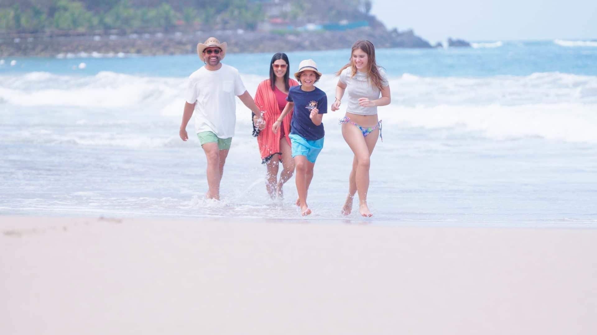 A beach scene with people walking along the shore.