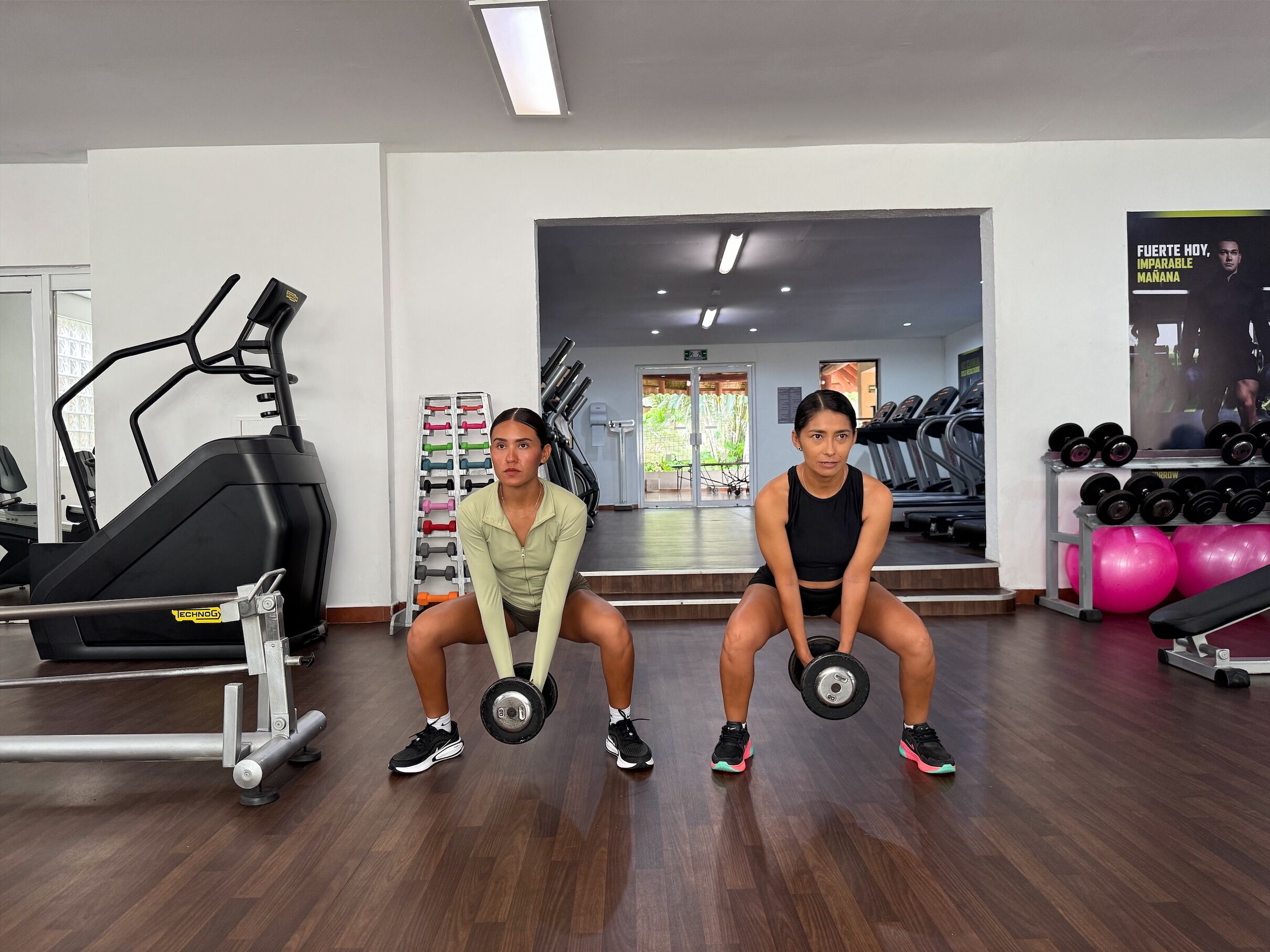 A gym with treadmills, dumbbells, and exercise balls.