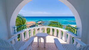 A balcony with a view of the ocean, white furniture, and a turquoise railing. - Franklyn D. Resort & Spa (Runaway Bay)