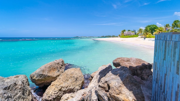 A beach with clear turquoise water, white sand, and rocky outcrops. - Franklyn D. Resort & Spa (Runaway Bay)