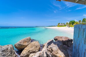 A beach with clear turquoise water, white sand, and rocky outcrops. - Franklyn D. Resort & Spa (Runaway Bay)