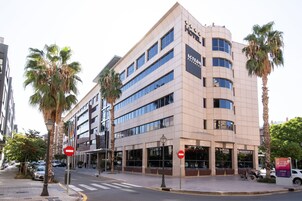 Un hotel de diseño moderno, con varios pisos y amplias ventanas.