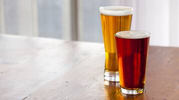 Two glasses of beer on a wooden table.
