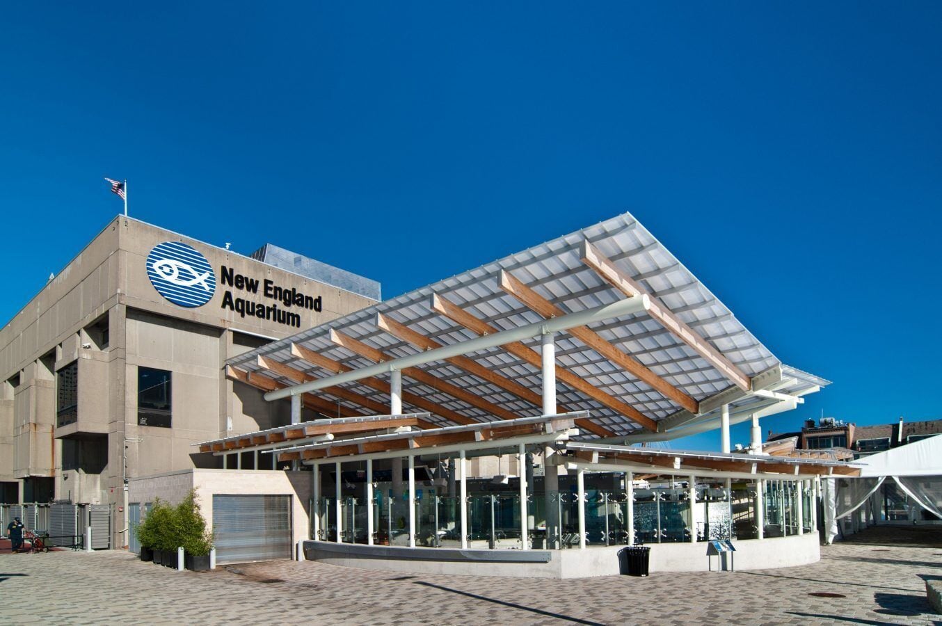 The exterior of the New England Aquarium with a modern design, featuring a large glass entrance and a covered outdoor area.
